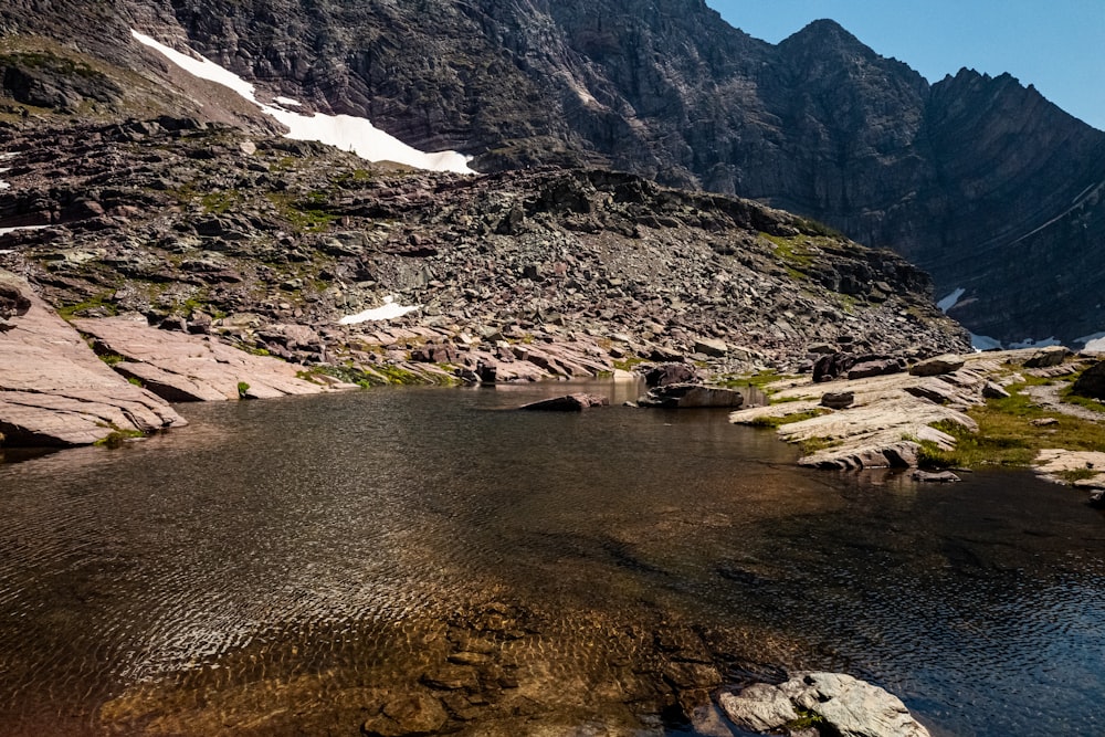 body of water near mountain during daytime