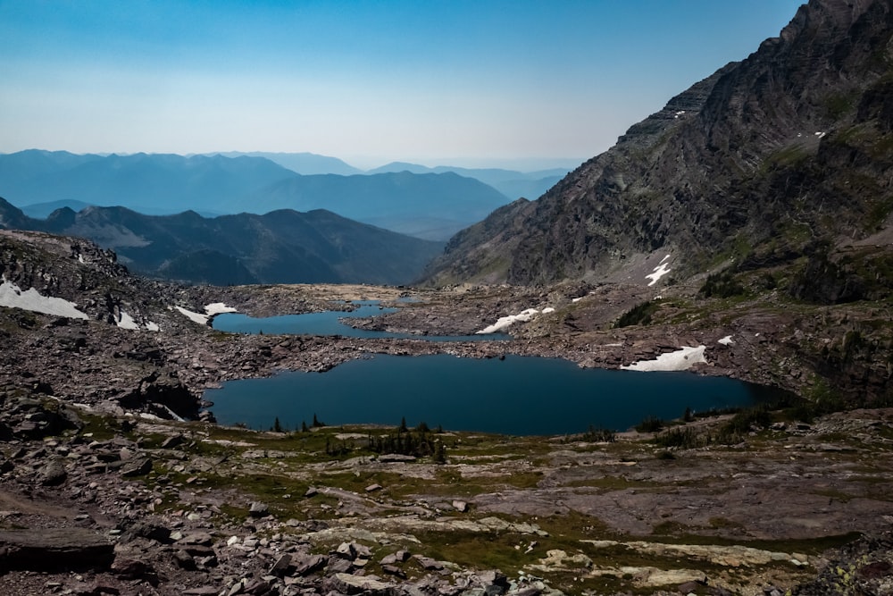 lake in the middle of mountains during daytime