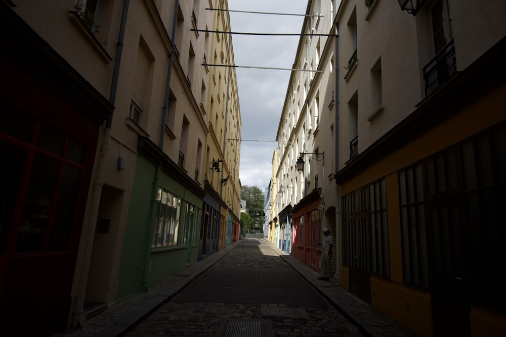 empty street between concrete buildings during daytime