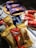 A collection of packaged ice cream bars featuring brands like Toblerone, Oreo, and Daim is displayed in a well-lit setting. The bars are arranged in an angled composition, with some lying in a plastic container in the foreground and others on a wooden tray in the background.
