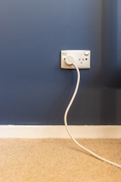 white electric plug on blue wall