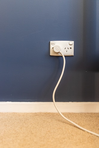 white electric plug on blue wall
