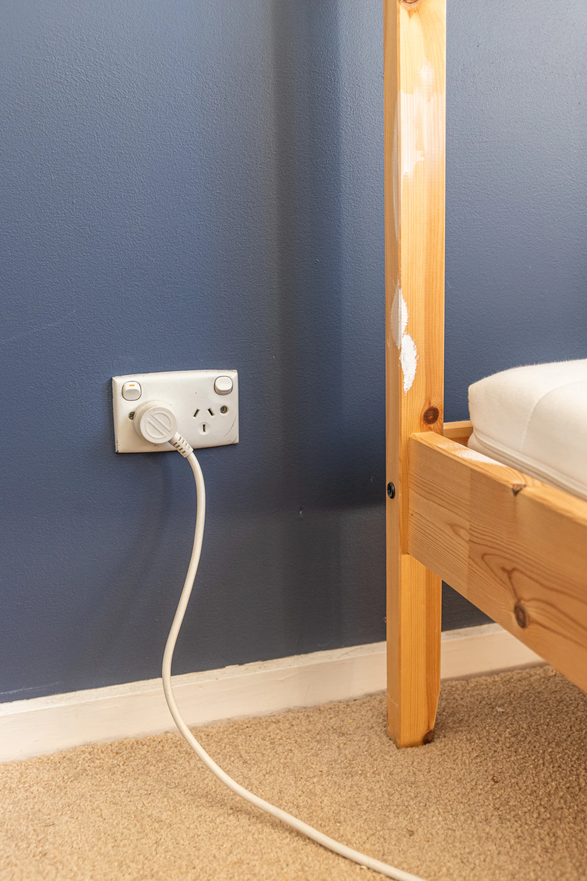 A white UK electric plug in a wall socket