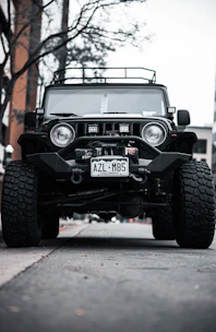 Off-road accessories like roof racks and recovery gear mounted on a Jeep Wrangler JK under a clear sky.
