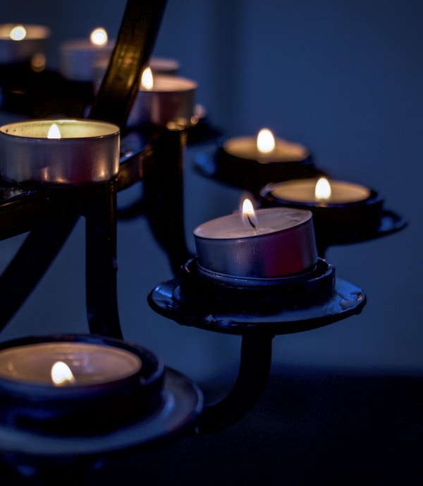 lighted candles on black metal candle holder