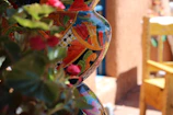 Hand-painted ceramic vase with intricate patterns displayed next to a cozy window.