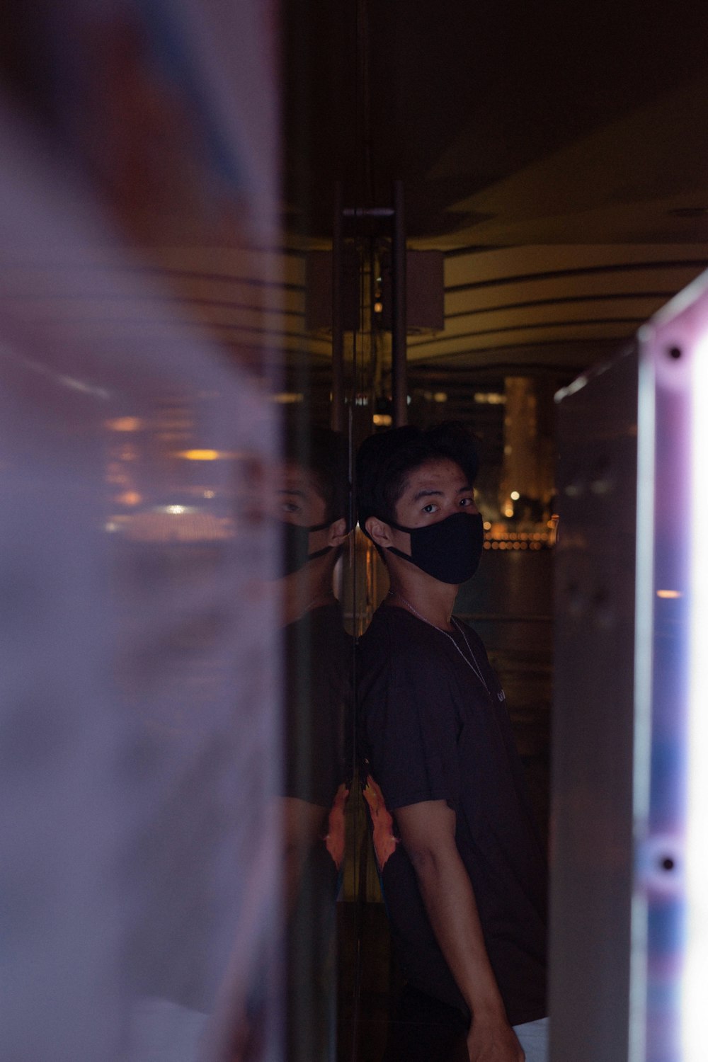 man in blue polo shirt standing near glass window