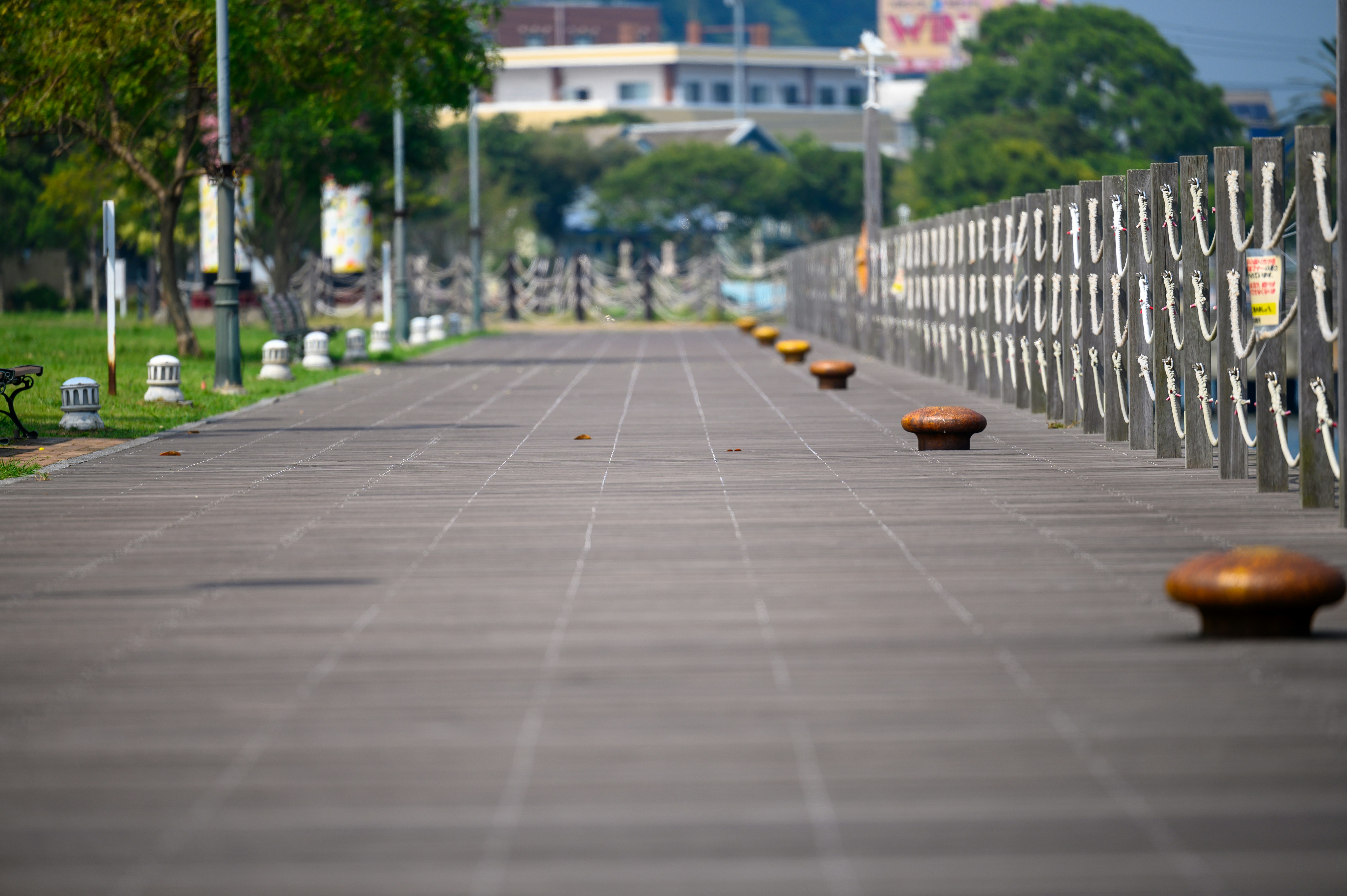 Brown wooden pathway with a gray metal fence