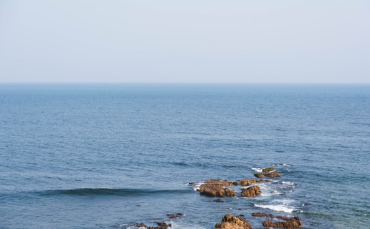 brown rock formation on sea during daytime in Visakhapatnam India