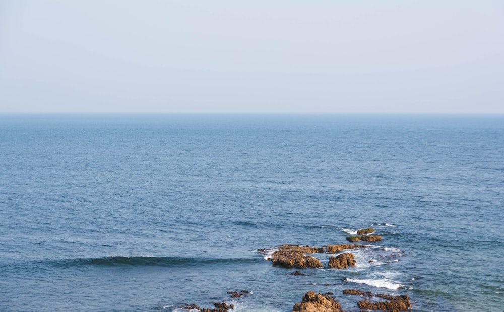 brown rock formation on sea during daytime