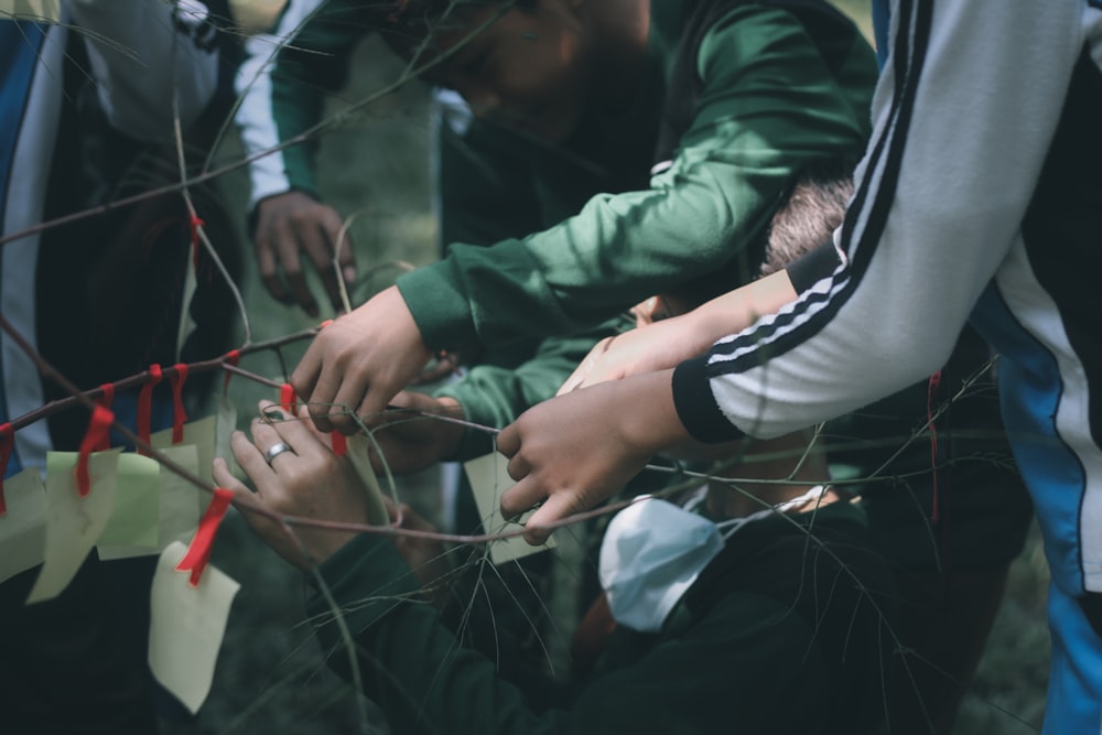 person in green jacket holding white and red ribbon