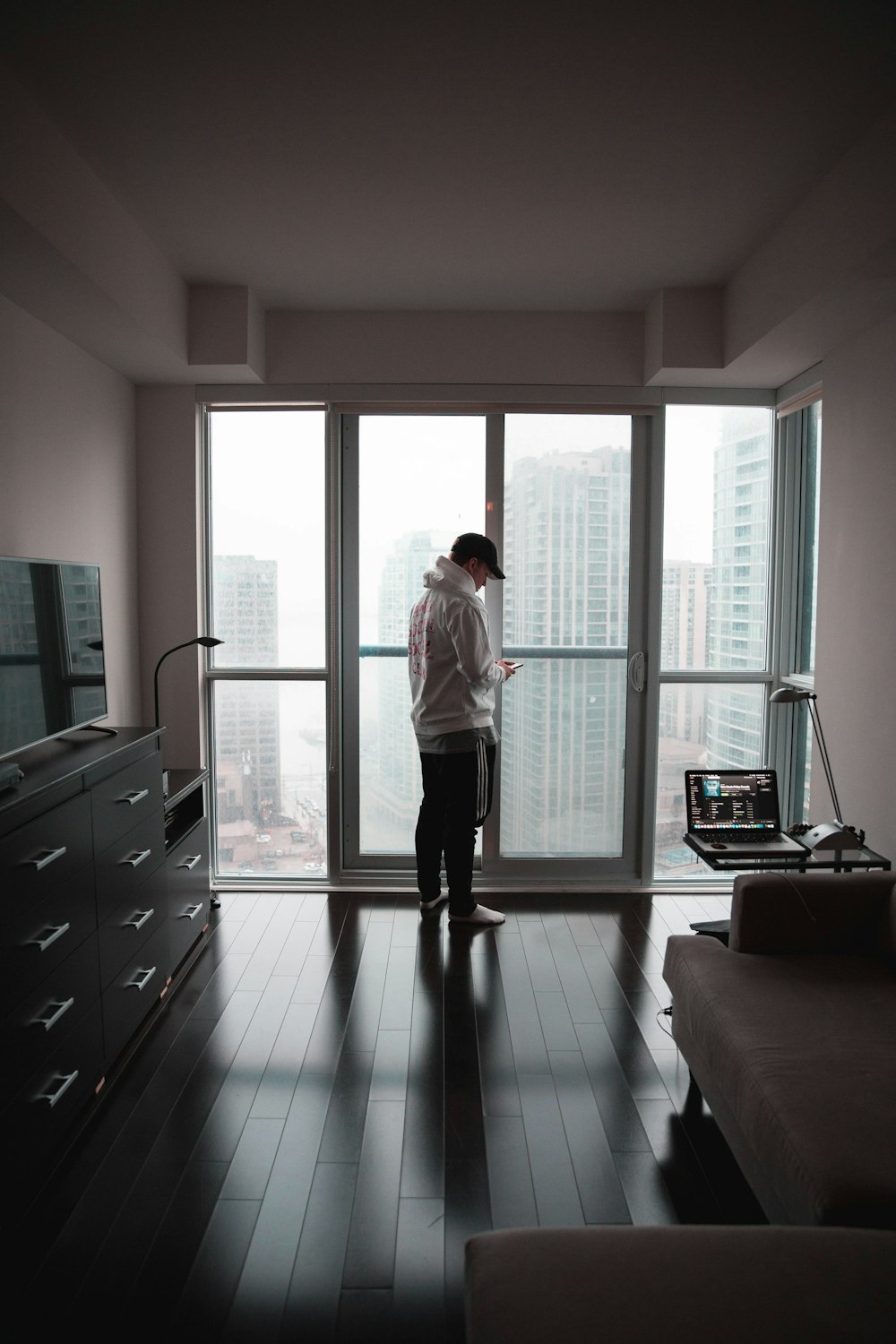 woman in white long sleeve shirt and black pants standing on black floor