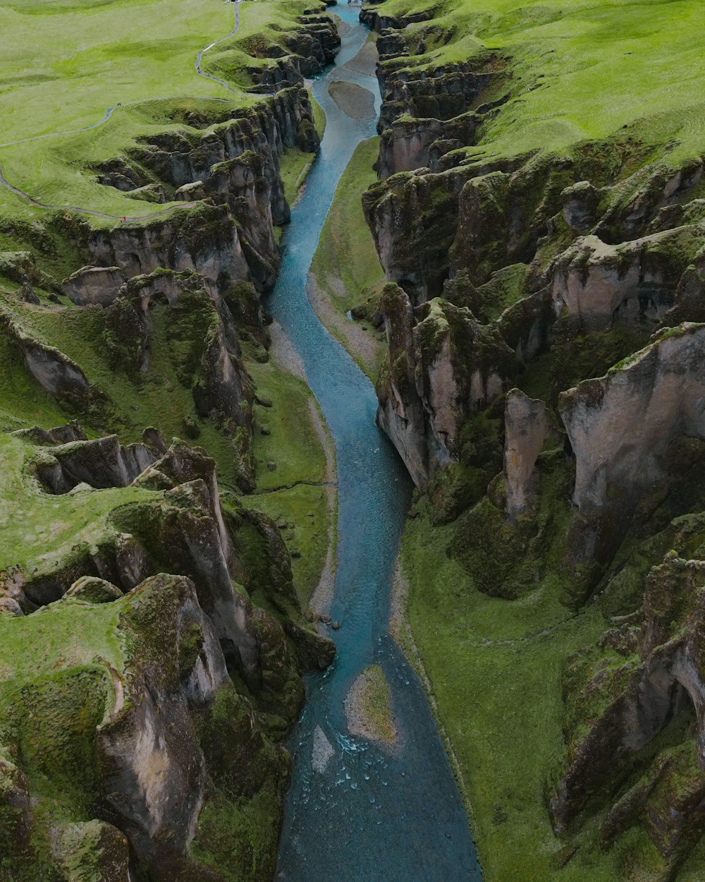 푸른 잔디로 덮인 언덕 한가운데에 있는 강