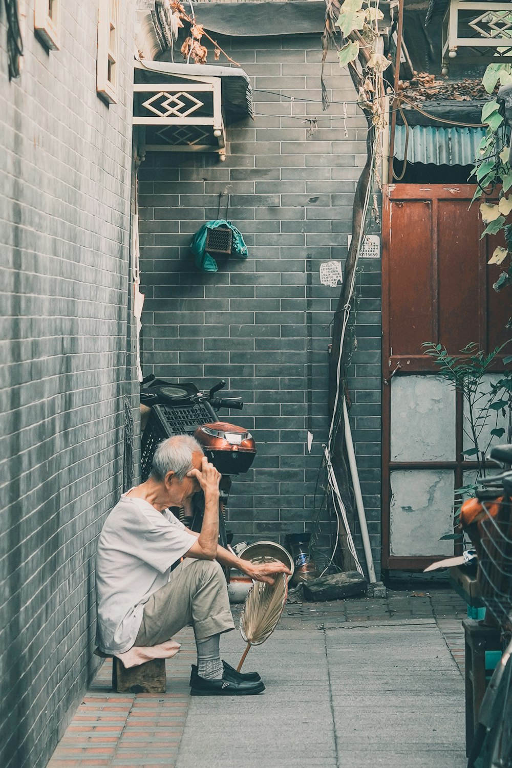 man in white shirt and brown pants sitting on brown woven chair