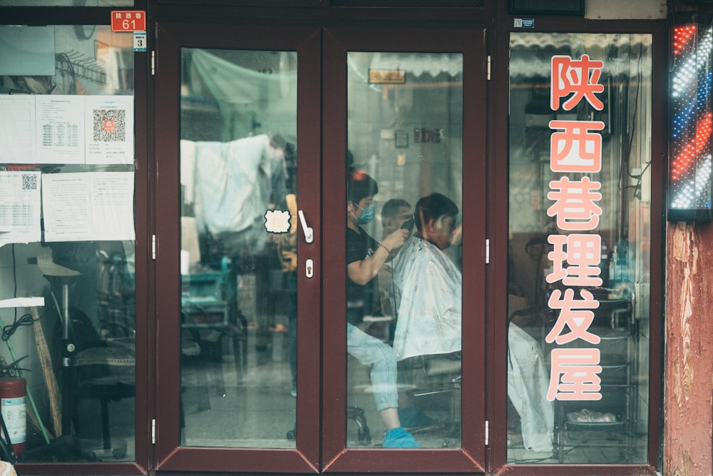 man in white dress shirt sitting on chair in front of glass door