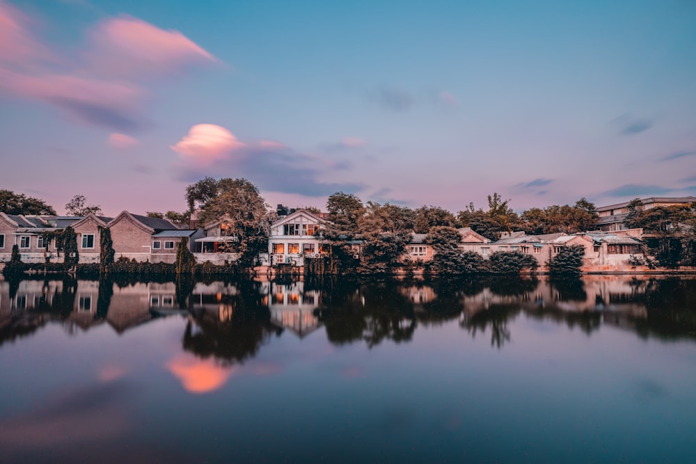 Casas marrones y blancas cerca del lago bajo el cielo azul durante el día