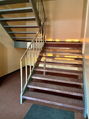 Modern steel staircase installed inside a commercial building with natural lighting.