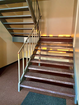 Modern steel staircase installed inside a commercial building with natural lighting.