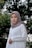 woman in white hijab standing near green trees during daytime
