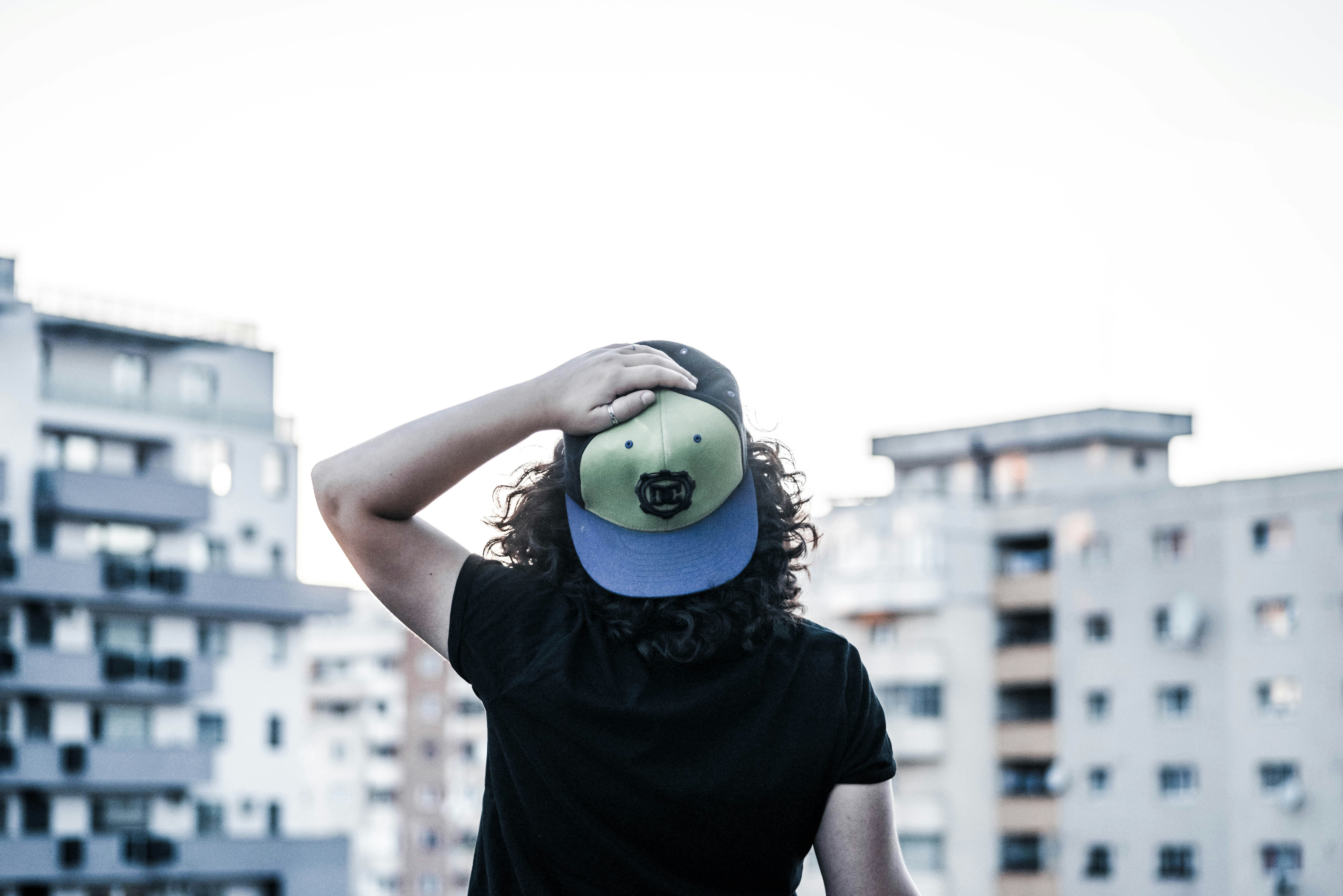 man in black t-shirt holding green and white ball