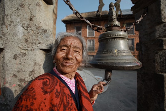 man in orange and black robe smiling in Katmandu Nepal