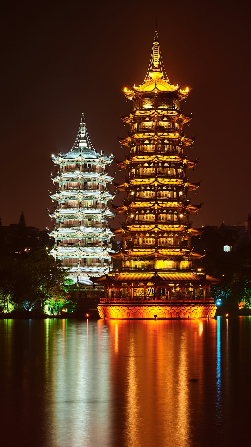 brown concrete building near body of water during night time