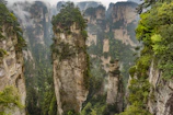 Stunning aerial view of Zhangjiajie's towering sandstone pillars shrouded in mist.