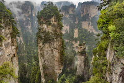 Stunning aerial view of Zhangjiajie's towering sandstone pillars shrouded in mist.