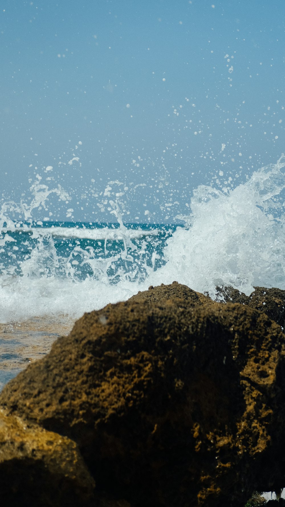 ocean waves crashing on brown rock