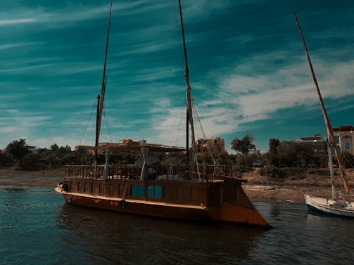 A traditional wooden boat anchored near the shore at dawn.