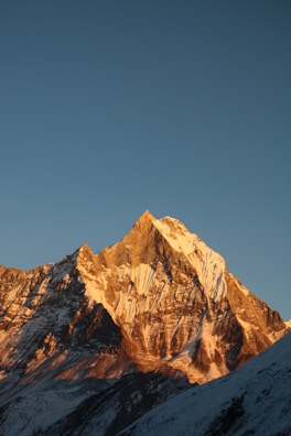 A hyper-realistic image of a mountain peak bathed in golden sunrise light