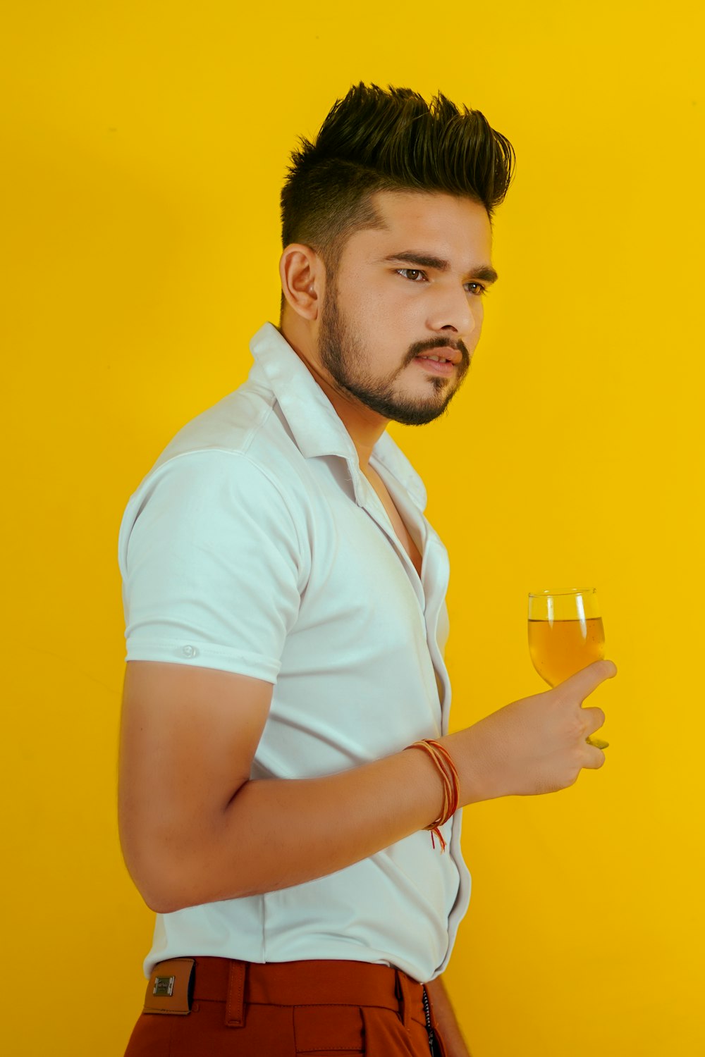 man in white polo shirt holding drinking glass