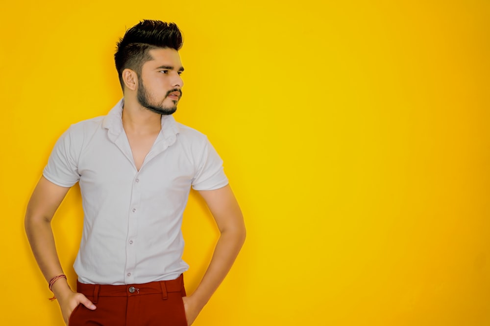 Hombre con camisa blanca abotonada y pantalones rojos