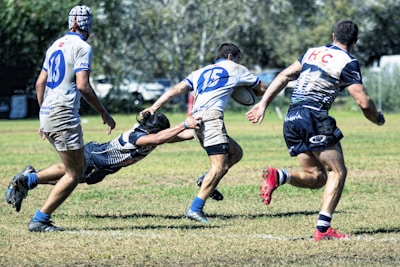 group of men playing soccer on green grass field during daytime