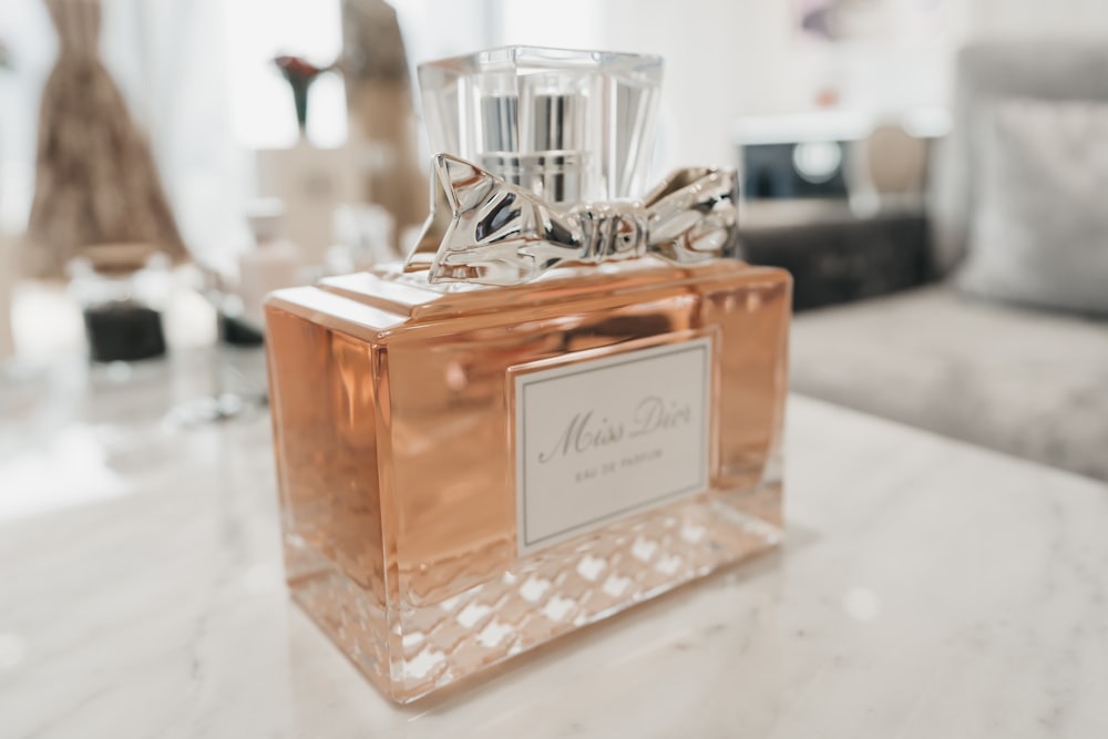 clear glass perfume bottle on white table