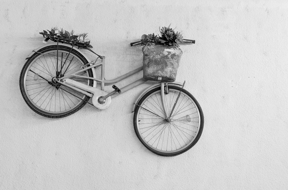 black bicycle with basket on white wall
