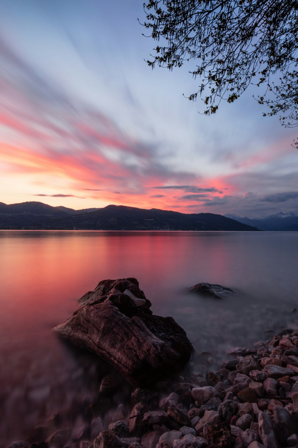 body of water near mountain during sunset