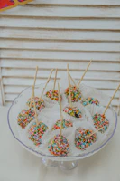 A colorful assortment of cake pops decorated with sprinkles and icing.