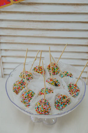 A colorful assortment of cake pops decorated with sprinkles and icing.