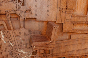 Close-up of a detailed metal sculpture made from recycled scrap parts, showing textures and rust.