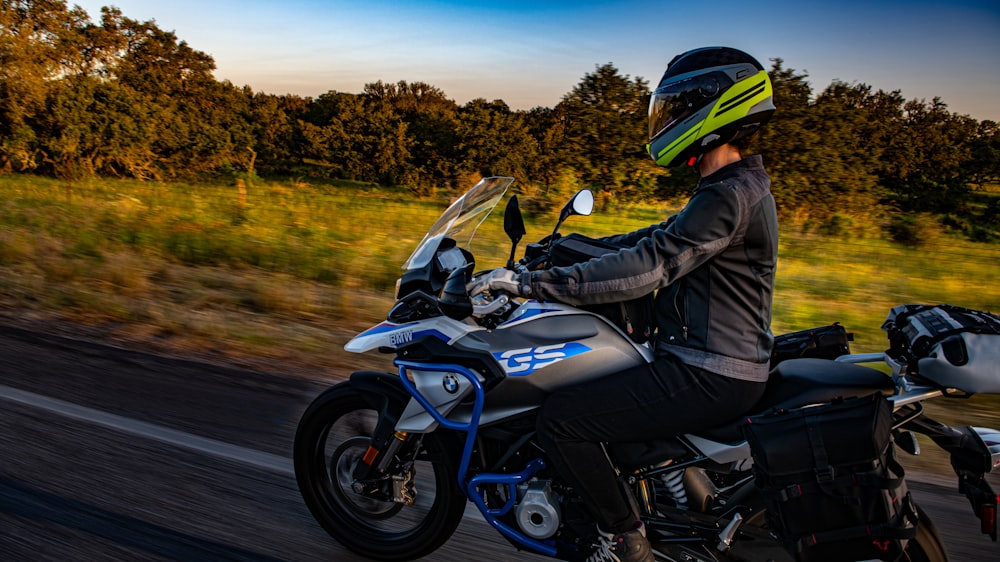 man in black jacket riding blue and black sports bike on road during daytime