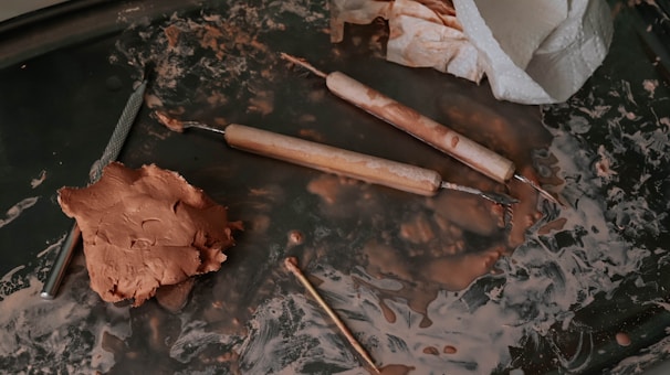 A creative workspace with tools and materials for making clay accessories.