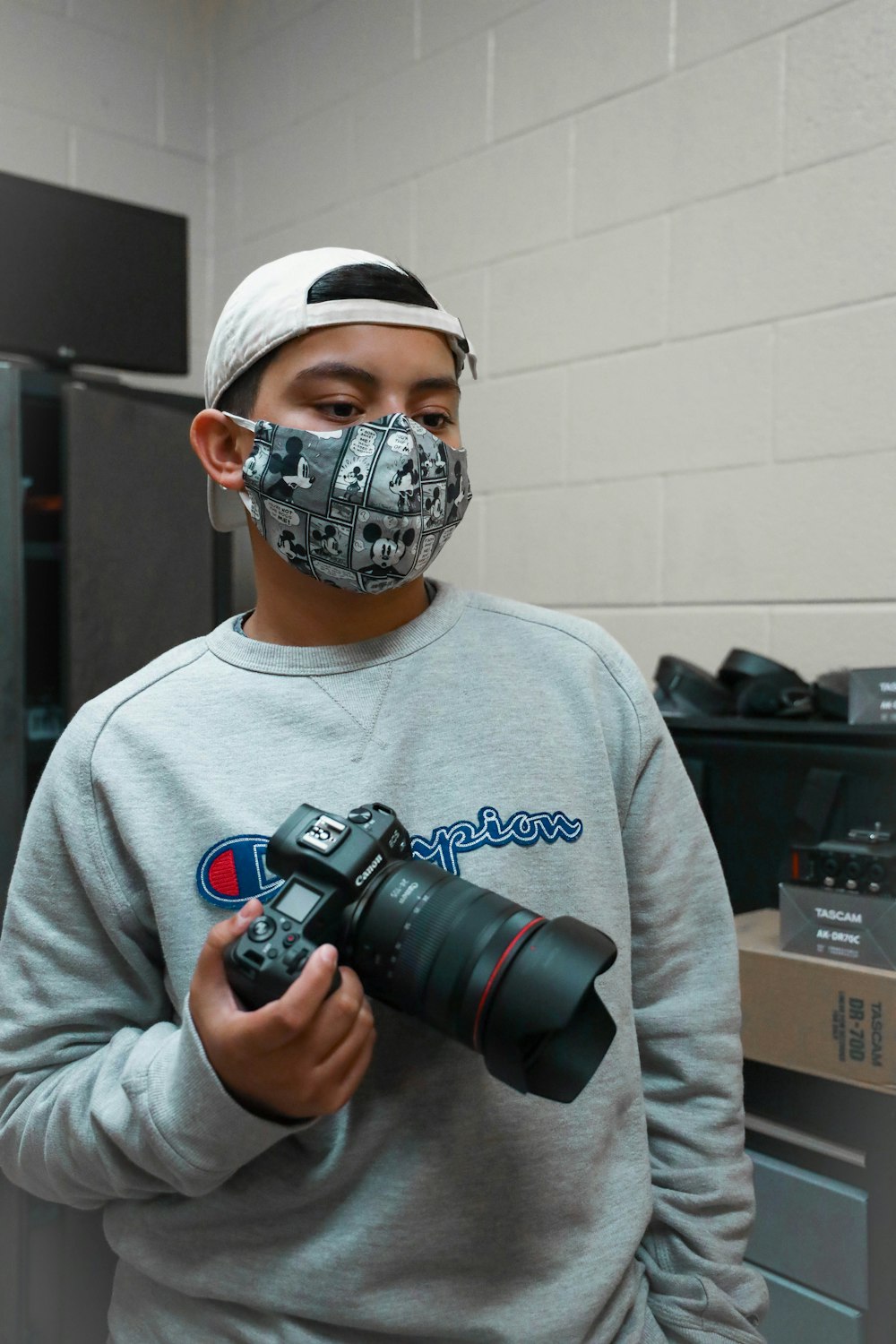 man in gray crew neck shirt holding black dslr camera