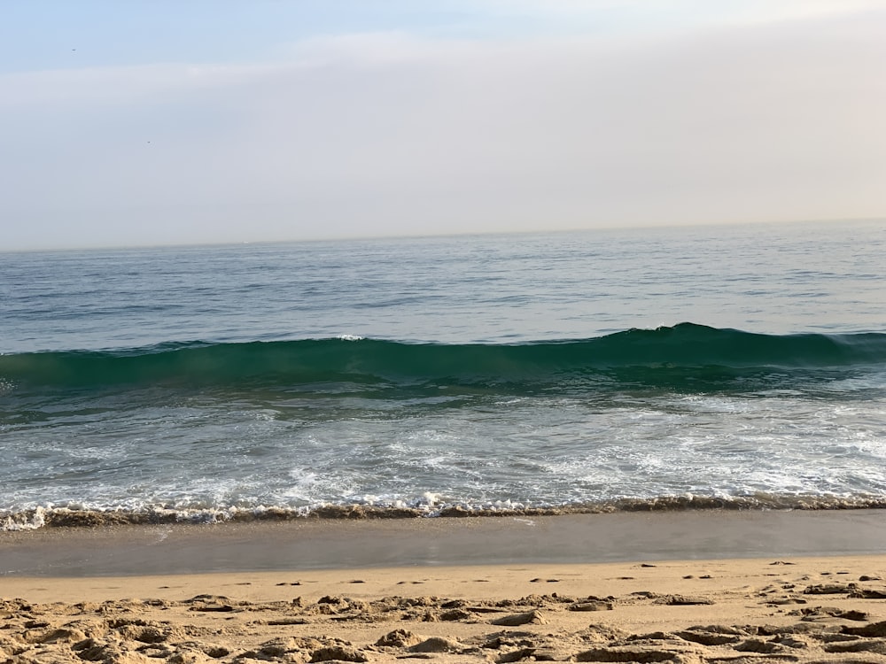 ocean waves crashing on shore during daytime