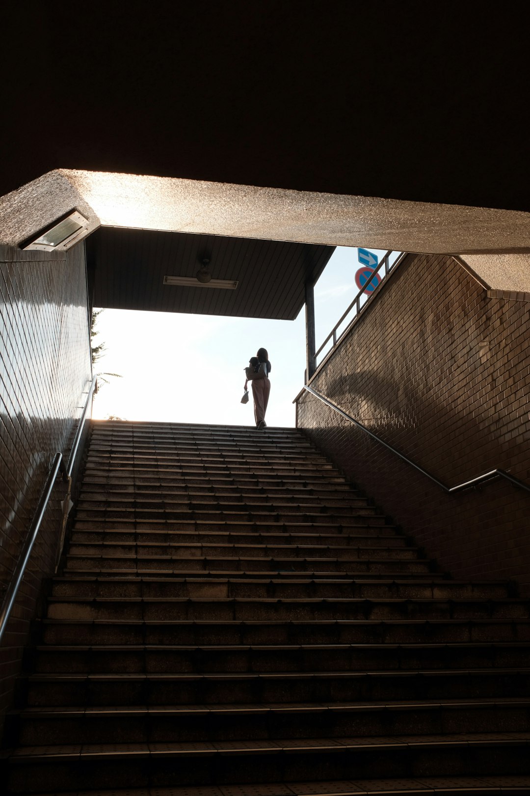 man in white shirt and black pants walking down the stairs