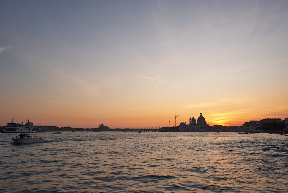 silhouette of boat on sea during sunset