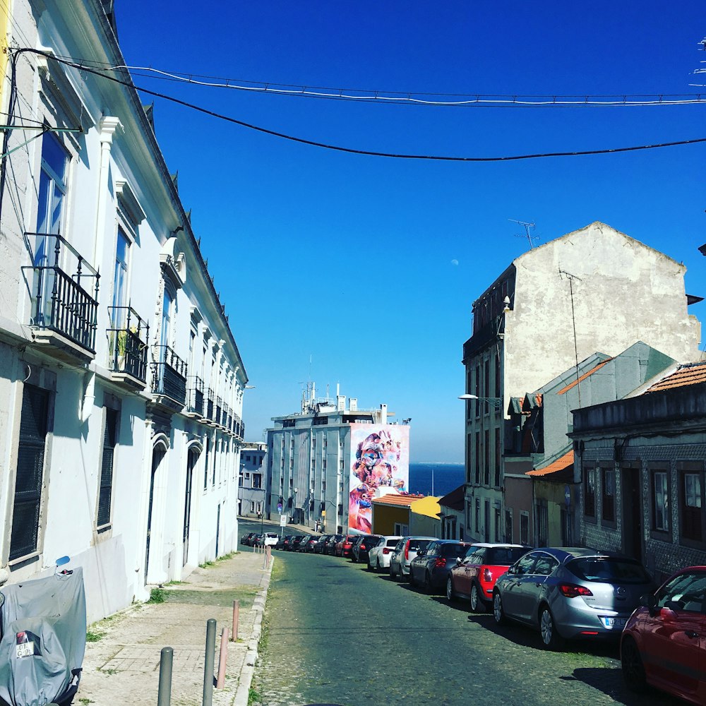 cars parked on side of the road in between buildings