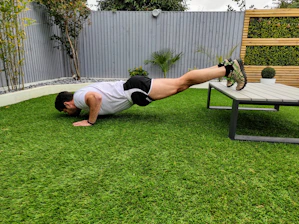 Middle-aged businessman performing bodyweight push-ups in a park