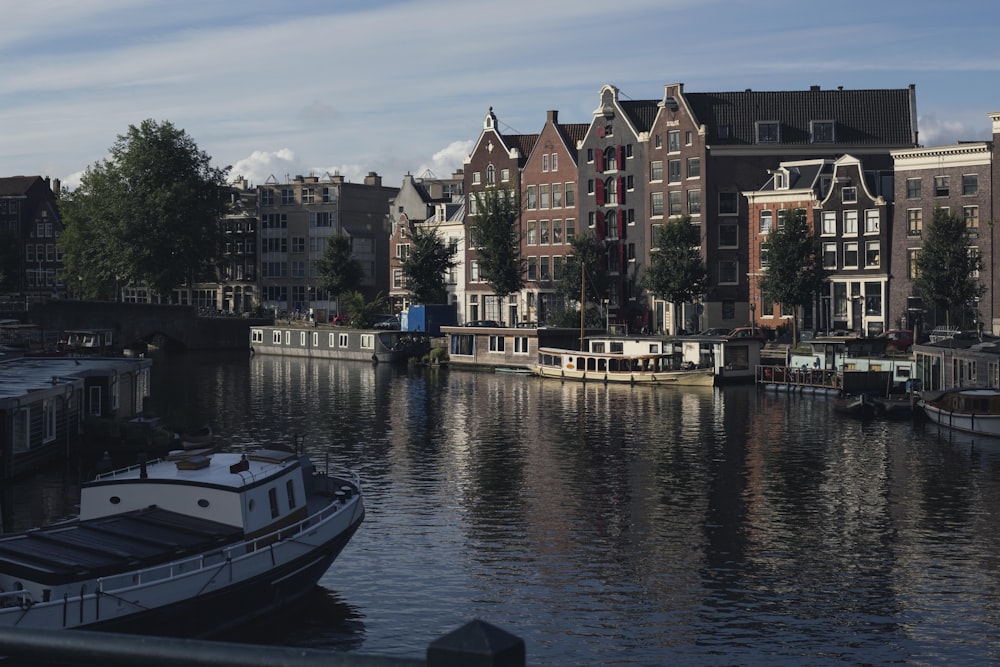 Barco blanco y azul en el río cerca de los edificios de la ciudad durante el día