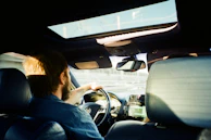 man in blue jacket driving car